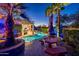 Inviting backyard pool with desert landscaping, lighting, and covered patio for relaxing and entertaining at 19644 N Majestic Vista Ct, Surprise, AZ 85387