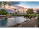 Scenic water view overlooking the golf course with mature landscaping and palm trees at sunset at 19644 N Majestic Vista Ct, Surprise, AZ 85387