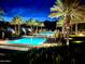 Night view of community pools lit up with palm trees, offering a tranquil and luxurious ambiance at 20721 W Fern Dr, Buckeye, AZ 85396