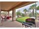 Inviting backyard featuring covered patio, BBQ grill, swimming pool, and putting green for outdoor enjoyment at 22139 N O Sullivan Dr, Maricopa, AZ 85138