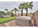 Beautiful backyard oasis with a hot tub, putting green, pool, and tropical palm trees for ultimate relaxation at 22139 N O Sullivan Dr, Maricopa, AZ 85138
