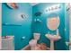 Stylish aqua half-bathroom featuring a pedestal sink, bright lighting, and decorative fish wall hangings at 22139 N O Sullivan Dr, Maricopa, AZ 85138