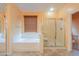 Bright bathroom showcasing a large soaking tub and separate glass-enclosed shower with a window at 22139 N O Sullivan Dr, Maricopa, AZ 85138