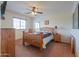Comfortable bedroom with wooden furniture, natural light from the window, and a calming color scheme at 22139 N O Sullivan Dr, Maricopa, AZ 85138