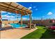 Inviting backyard oasis with pool, patio seating, artificial grass, and a pergola at 23791 W Magnolia Dr, Buckeye, AZ 85326