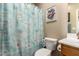 The bathroom features a toilet, shower curtain with a boat theme, and seashell decor at 23791 W Magnolia Dr, Buckeye, AZ 85326