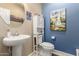 A charming powder room features a pedestal sink and stylish nautical themed decorations at 23791 W Magnolia Dr, Buckeye, AZ 85326