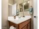 Bathroom features a wood vanity with a white sink, framed mirror, and towel rack at 23791 W Magnolia Dr, Buckeye, AZ 85326