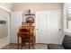 Cozy bedroom featuring a wooden rolltop desk, chair, and closet with paneled doors at 23791 W Magnolia Dr, Buckeye, AZ 85326