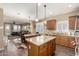 Kitchen with granite island and stainless steel appliances, opens to dining area and adjacent living room at 23791 W Magnolia Dr, Buckeye, AZ 85326