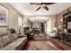 Inviting living room with ceiling fan and hardwood floors seamlessly connects to dining area and kitchen at 23791 W Magnolia Dr, Buckeye, AZ 85326
