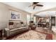 Spacious living room with plush seating, rug, and hardwood floors, flowing into the dining and kitchen area at 23791 W Magnolia Dr, Buckeye, AZ 85326