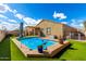 Inviting backyard pool area with a lounge area and artificial grass for low maintenance and outdoor enjoyment at 23791 W Magnolia Dr, Buckeye, AZ 85326