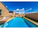 Backyard pool area with clear blue water, surrounded by brick trim, artificial turf, and privacy walls at 23791 W Magnolia Dr, Buckeye, AZ 85326