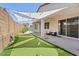 Inviting backyard with covered patio, putting green, and string lights for outdoor relaxation and entertainment at 24878 N 172Nd Dr, Surprise, AZ 85387