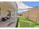 Inviting backyard with covered patio, putting green, and string lights for outdoor relaxation and entertainment at 24878 N 172Nd Dr, Surprise, AZ 85387