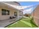 Inviting backyard with covered patio, putting green, and string lights for outdoor relaxation and entertainment at 24878 N 172Nd Dr, Surprise, AZ 85387