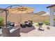 Inviting backyard patio with seating area, umbrella, grill and desert landscaping for entertaining at 24878 N 172Nd Dr, Surprise, AZ 85387