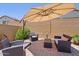 Backyard patio with comfortable seating, umbrella, and landscaped details for outdoor enjoyment at 24878 N 172Nd Dr, Surprise, AZ 85387