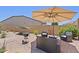 Backyard patio with comfortable seating, umbrella, hammock, grill and desert landscaping for entertaining at 24878 N 172Nd Dr, Surprise, AZ 85387