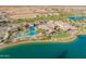 Aerial view of the community pool and clubhouse overlooking a lake with palm trees at 24878 N 172Nd Dr, Surprise, AZ 85387