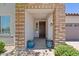 Inviting entryway with a brick surround, dark wood door, and stylish blue planters at 24878 N 172Nd Dr, Surprise, AZ 85387
