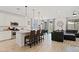 Modern kitchen open to the living room with white cabinetry, island seating, and stainless appliances at 24878 N 172Nd Dr, Surprise, AZ 85387