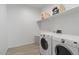 Efficient laundry room with modern appliances and shelving for organized storage and convenience at 24878 N 172Nd Dr, Surprise, AZ 85387