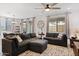 Open-concept living room with a ceiling fan and large sectional sofa for comfortable seating at 24878 N 172Nd Dr, Surprise, AZ 85387