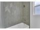 Updated bathroom featuring stylish gray herringbone tiling in the shower and a sleek, modern shower head at 28834 N 175Th Ave, Surprise, AZ 85387