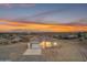 Single-story home featuring a modern garage door, clean white facade, and picturesque desert surroundings at sunset at 28834 N 175Th Ave, Surprise, AZ 85387