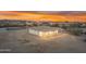 Rear view of a clean, single-story home featuring a covered patio, clean white facade, and picturesque desert surroundings at 28834 N 175Th Ave, Surprise, AZ 85387