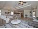 Open-concept living room with tile floors, comfortable seating, and a view of the kitchen at 3134 N 158Th Ave, Goodyear, AZ 85395