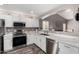 Well-lit kitchen with stainless steel appliances, white cabinets, and breakfast bar at 3423 E Crescent Way, Gilbert, AZ 85298