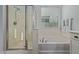 Bright bathroom featuring a shower stall, soaking tub with chrome fixtures, and a window with blinds at 3439 E Shannon St, Gilbert, AZ 85295