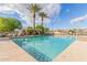 Resort-style community pool featuring clear water, lounge chairs and swaying palm trees on a bright day at 3439 E Shannon St, Gilbert, AZ 85295