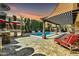 Outdoor living space with covered seating, BBQ, and sparkling pool surrounded by manicured landscaping at 3925 E Vallejo Dr, Gilbert, AZ 85298
