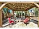 Inviting backyard gazebo area with chairs and a travertine tile floor and perimeter landscaping at 3925 E Vallejo Dr, Gilbert, AZ 85298