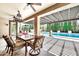 Inviting covered patio with chandelier, comfortable seating and views of pool and lush landscaping at 3925 E Vallejo Dr, Gilbert, AZ 85298