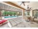 Expansive covered patio featuring a travertine tile floor, fans, and a pool view at 3925 E Vallejo Dr, Gilbert, AZ 85298