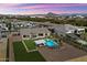 Aerial view of a landscaped property with a pool, mountain views and a grassy lawn at 4023 E Minton Cir, Mesa, AZ 85215