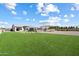 Expansive backyard with lush lawn, ideal for outdoor activities, with covered patio and fenced pool at 4023 E Minton Cir, Mesa, AZ 85215