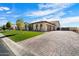 Spacious home features a wide driveway, three-car garage, and well-maintained turf and landscaping at 4023 E Minton Cir, Mesa, AZ 85215