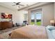 Bright main bedroom featuring ceiling fan, backyard access, and a dedicated office nook at 4023 E Minton Cir, Mesa, AZ 85215