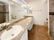 Bright bathroom offers double sinks, granite countertops and a large mirror at 4111 W Desert Cove Ave, Phoenix, AZ 85029