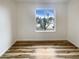 This empty bedroom features hardwood floors, a large window and bright light at 4111 W Desert Cove Ave, Phoenix, AZ 85029