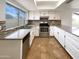A well-lit kitchen featuring white cabinets, stainless steel appliances and a large window at 4111 W Desert Cove Ave, Phoenix, AZ 85029