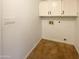 Simple laundry room with overhead storage cabinets and tile flooring at 4111 W Desert Cove Ave, Phoenix, AZ 85029