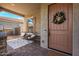Inviting front porch with neutral toned seating and brick flooring that leads to the lovely wood front door at 4237 E Sierra Madre Ave, Gilbert, AZ 85296