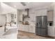 Open kitchen with stainless steel refrigerator, island, stylish range hood, and ample storage at 4237 E Sierra Madre Ave, Gilbert, AZ 85296